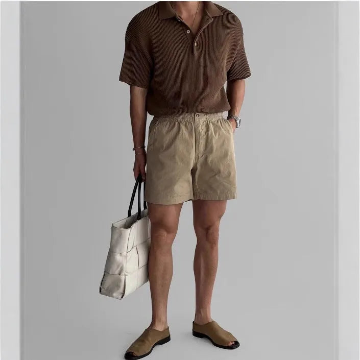 Cotton loose fit sports shorts in black, shown on a hanger.