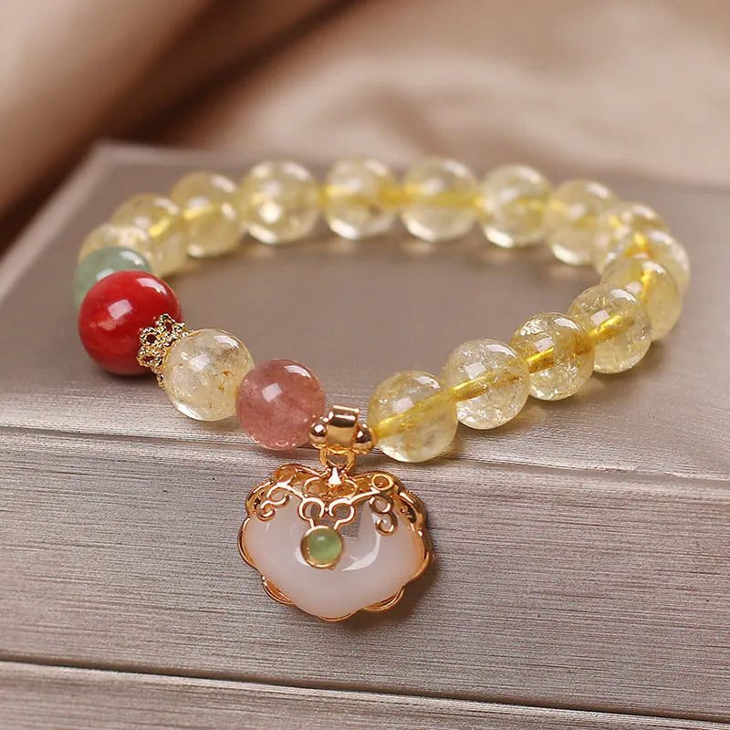 Close-up of a women's bracelet with a yellow citrine jade ruyi pendant on an adjustable alloy chain.