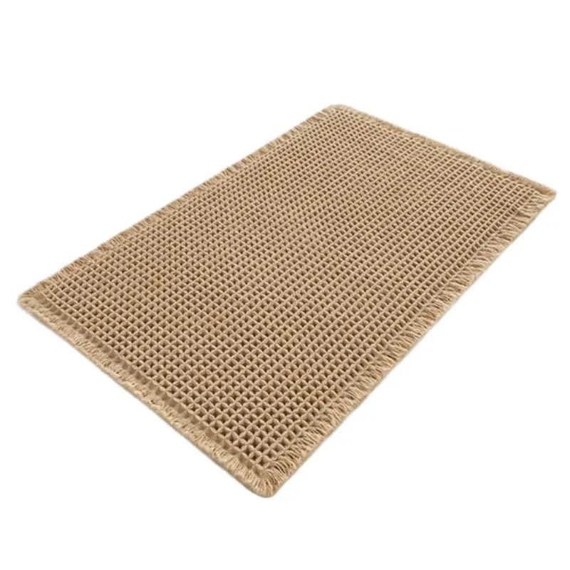 Square checkered pattern bath mat in beige colour on a bathroom floor.