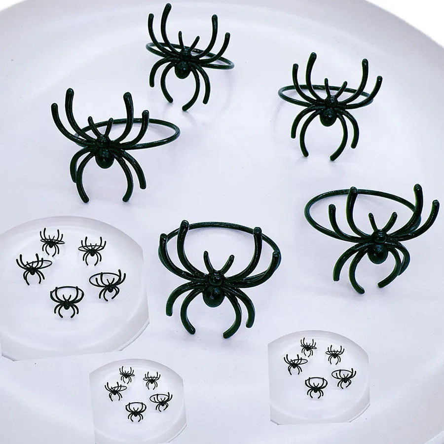 Set of six black spider patterned alloy napkin rings for Halloween table decoration
