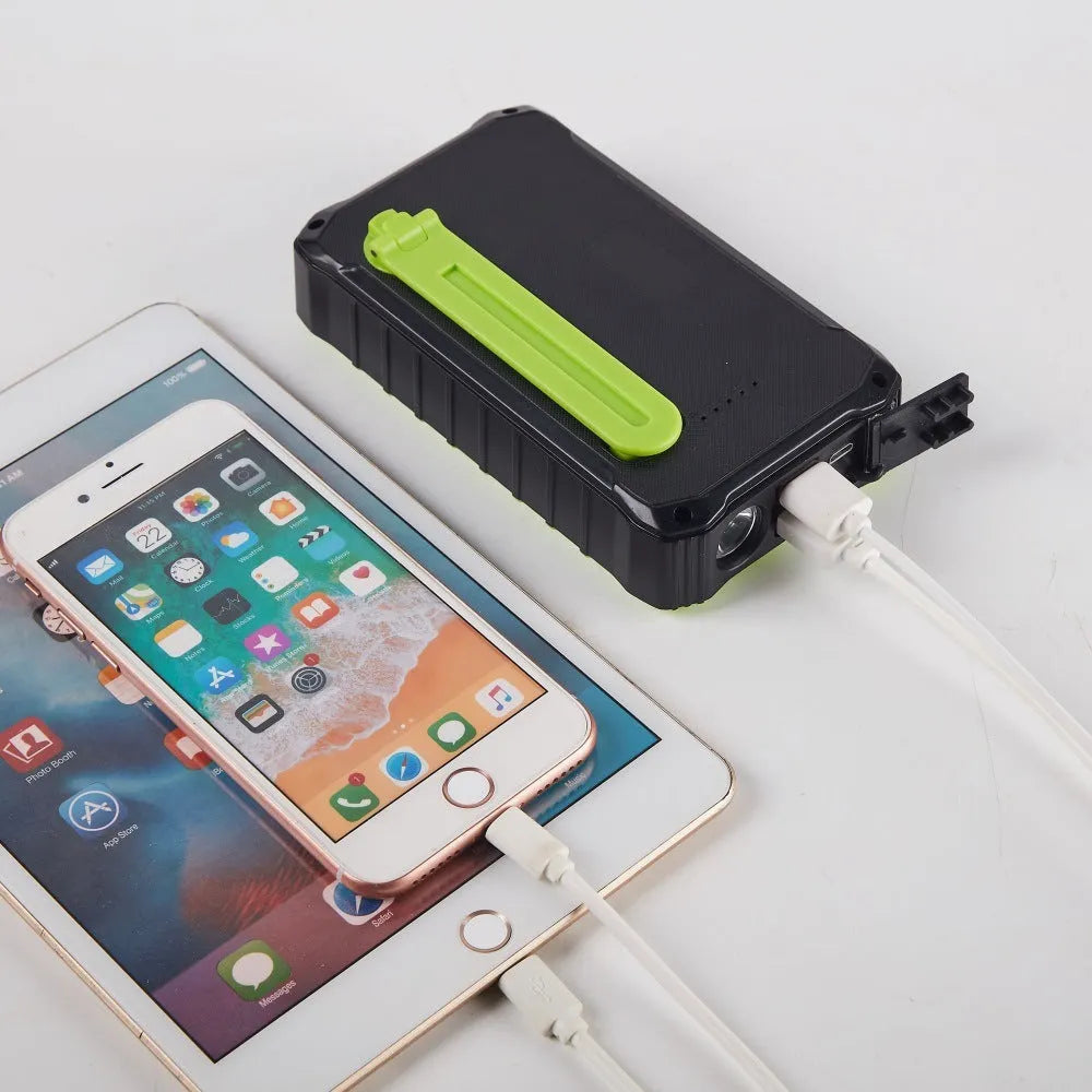 Orange or green hand crank solar power bank with solar panel, dual USB ports, and LED light.