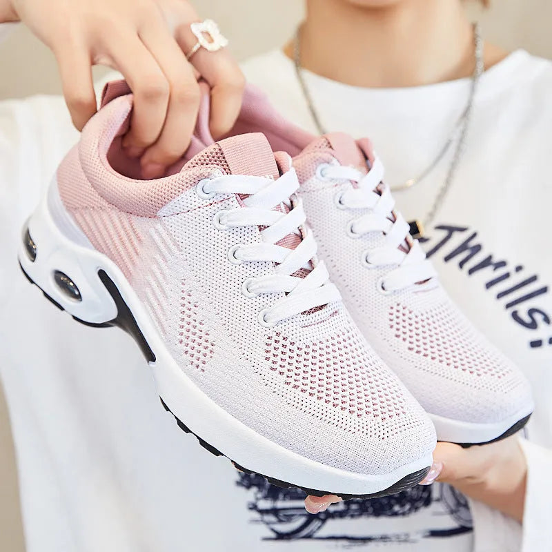 Women's pink Flyknit running shoes with a striped pattern, flat PVC sole, and lace-up front.