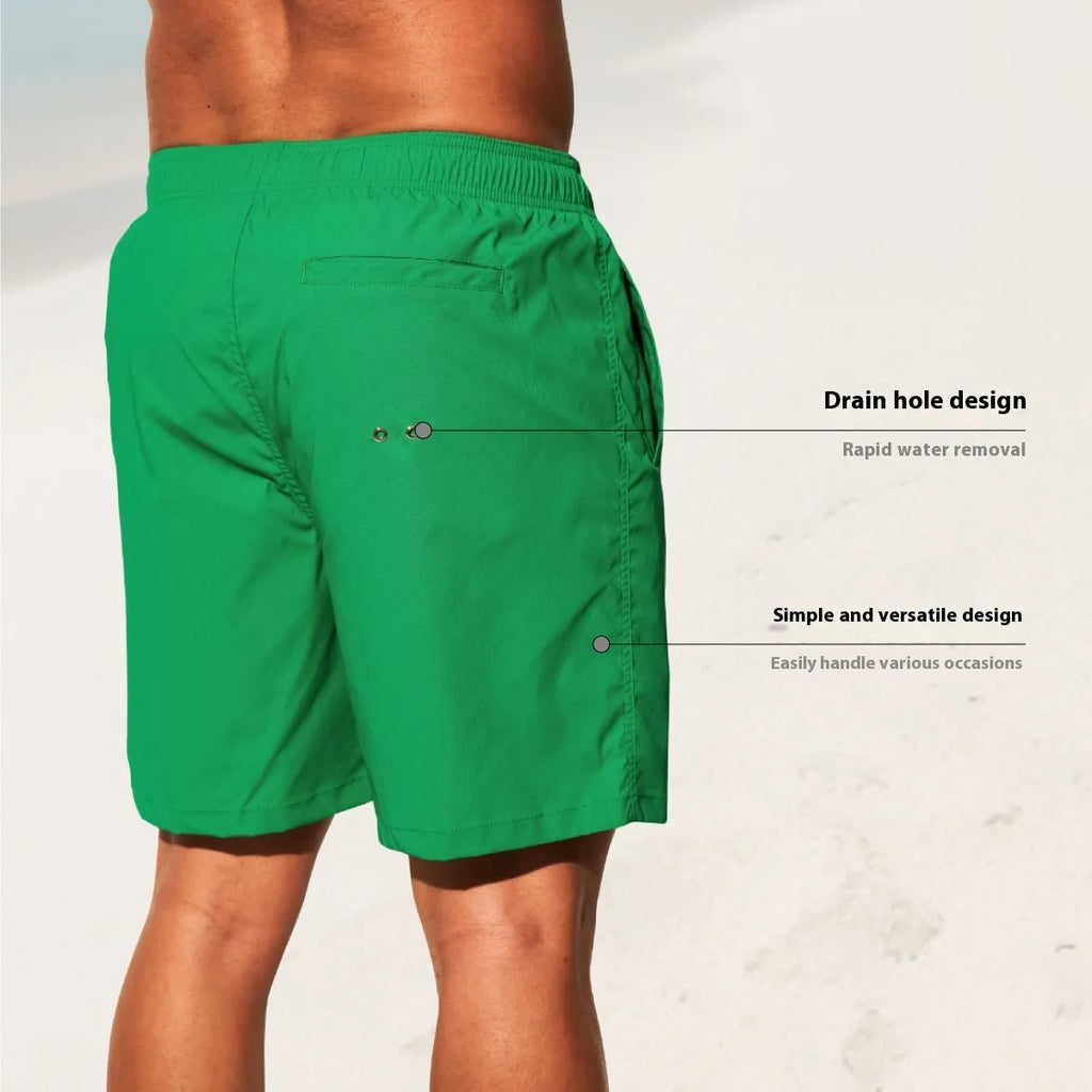 Man wearing solid green quick-drying nylon shorts with a straight leg opening on a beach.