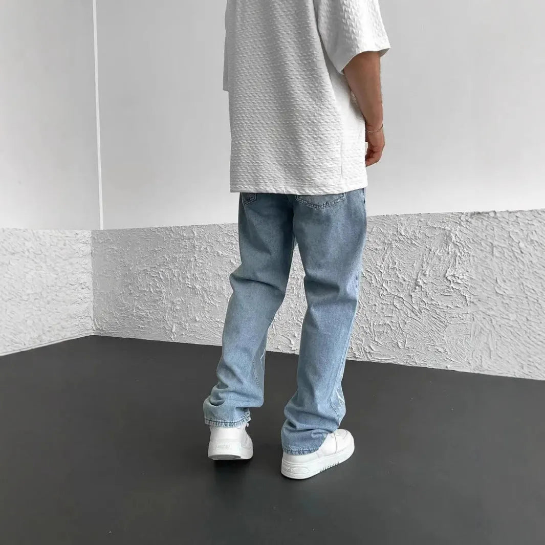 Men's blue straight-leg denim jeans with loose wide-leg cut and zip fly
