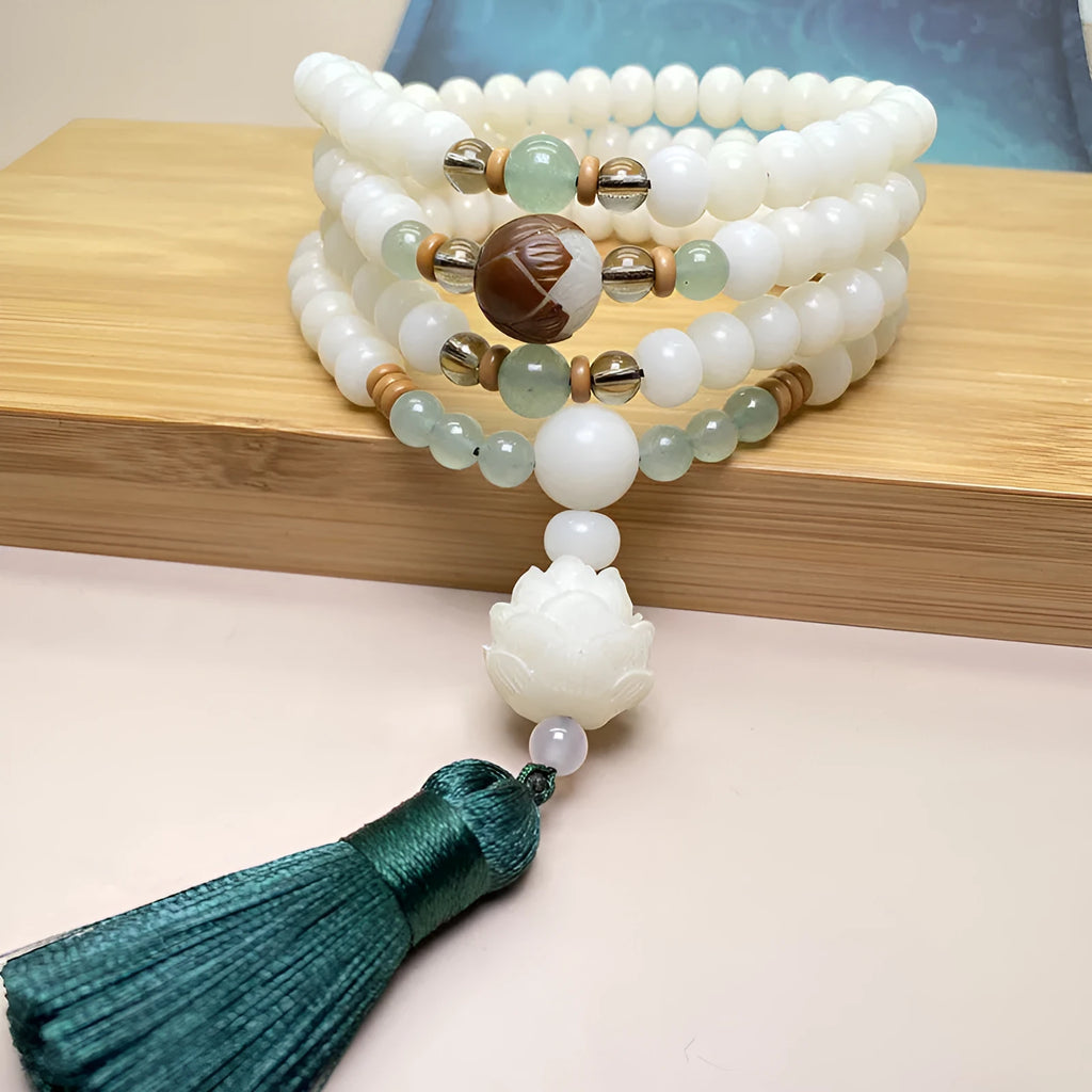 Close-up of a white jade Bodhi bead bracelet with 108 beads, showing different style patterns.