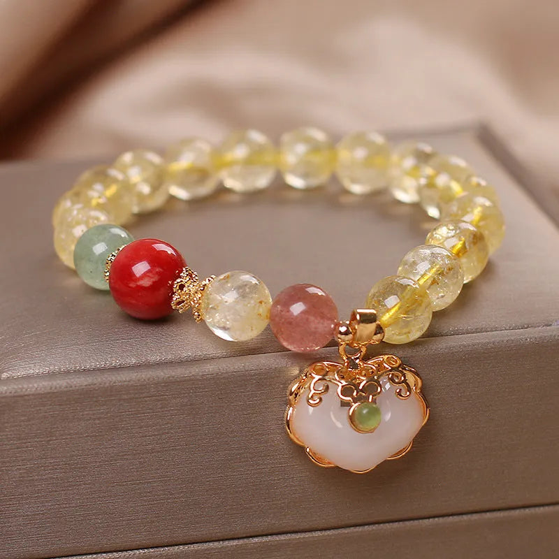 Close-up of a women's bracelet with a yellow citrine jade ruyi pendant on an adjustable alloy chain.