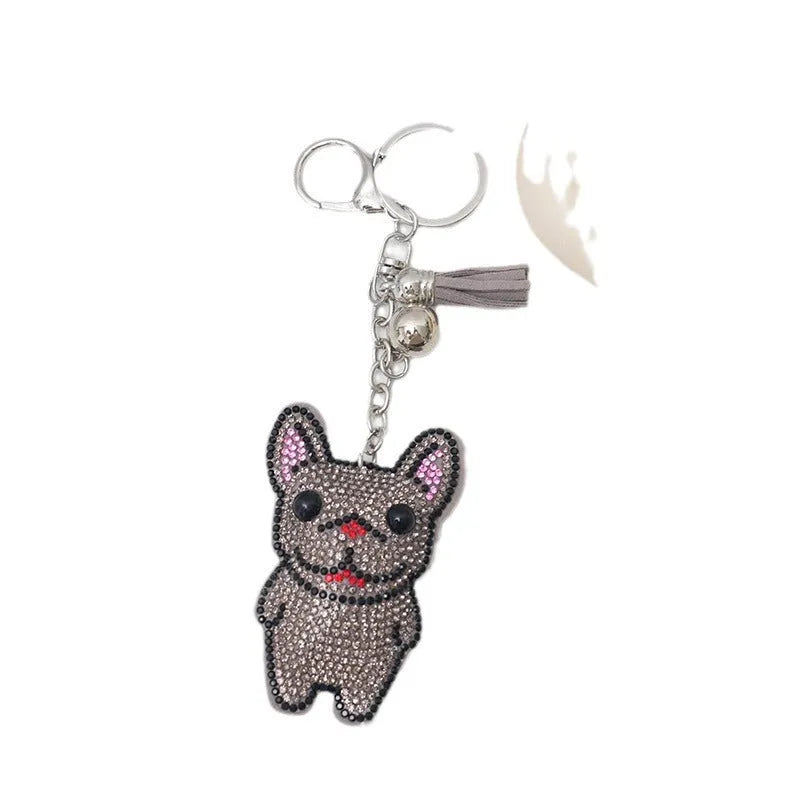 Close-up of a caramel-coloured cartoon dog rhinestone keychain pendant on a keyring.