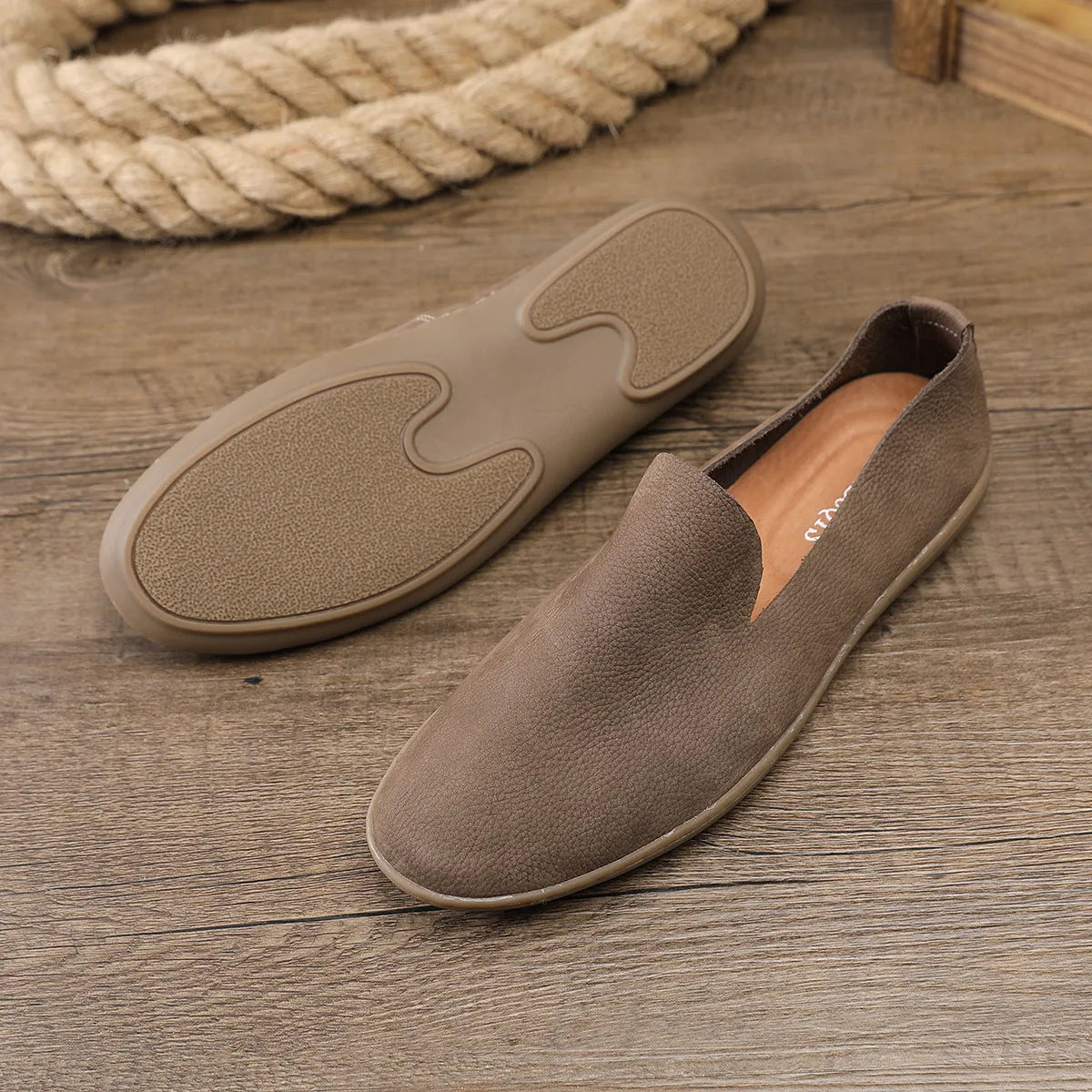 Handmade grey low-top men's shoes with a flat wedge heel and rubber sole.
