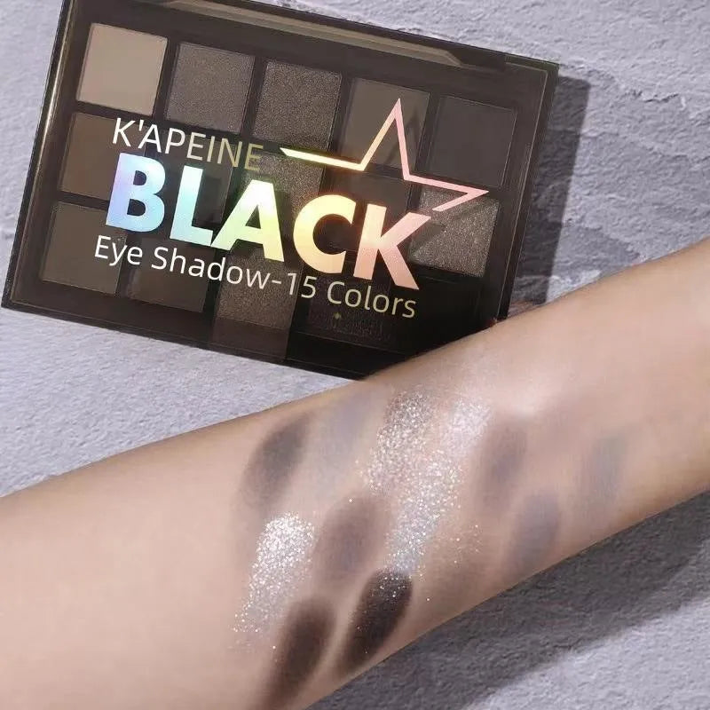 15-colour eye shadow palette showing matte and shimmer finishes in grey, black, brown and blue tones
