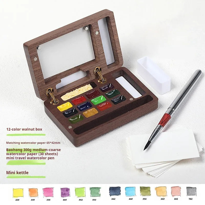 Miniature hinged wooden watercolour paint box open to show compartments for paints and brushes.