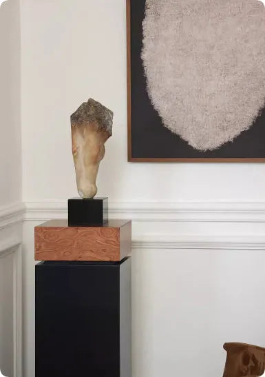 Tall abstract horse head sculpture with carved texture on a desk surface.