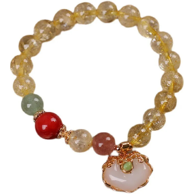 Close-up of a women's bracelet with a yellow citrine jade ruyi pendant on an adjustable alloy chain.