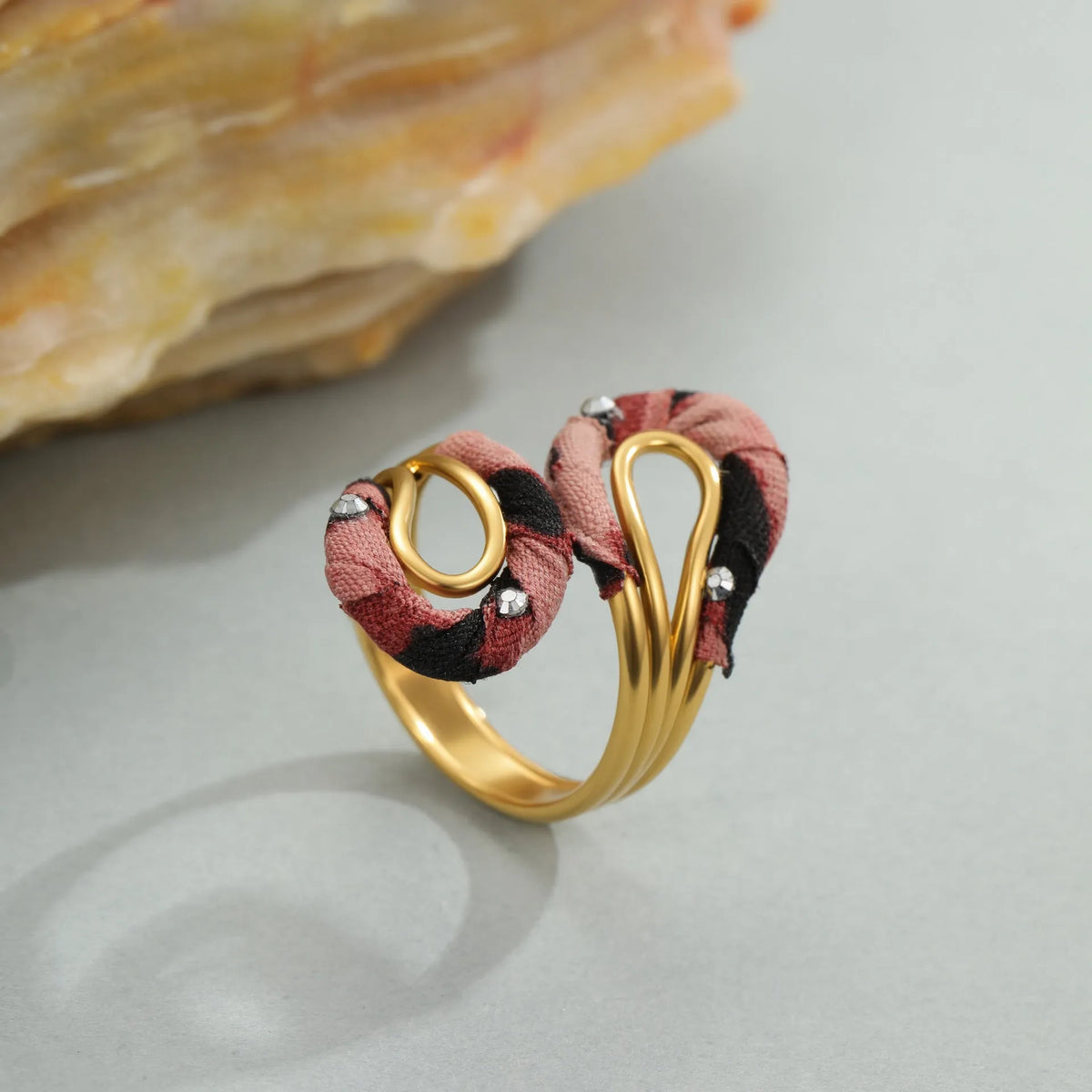Leopard print geometric open mouth stainless steel ring on a grey background.