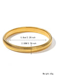 Gold titanium steel women's bracelet with vertical stripes and elastic ring design on a wrist.