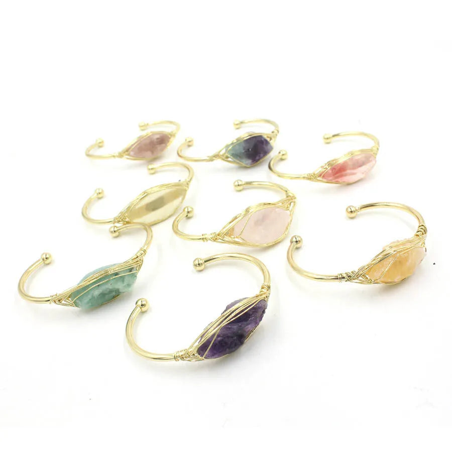 Natural raw gemstone bracelet in winding design on wrist, showing amorphous crystal stones and simple clasp.