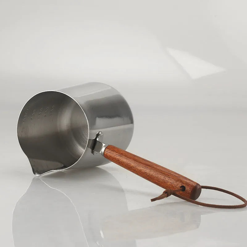 Stainless steel coffee cup with wooden handle and internal measuring scale.