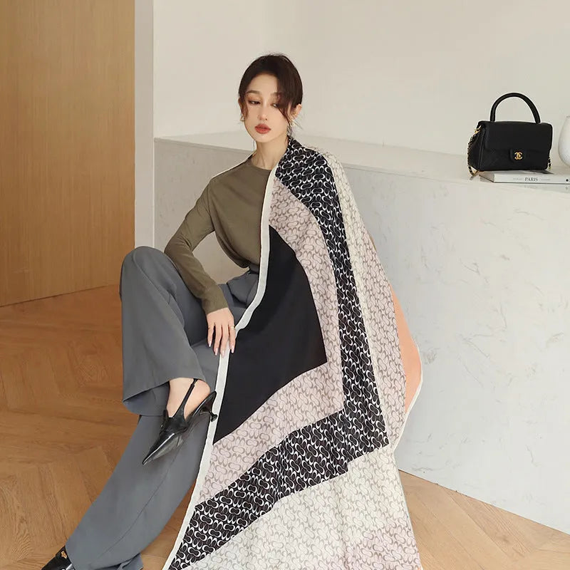 A woman wearing a printed polyester scarf, showing one of three style options, with dimensions of 180cm by 90cm.