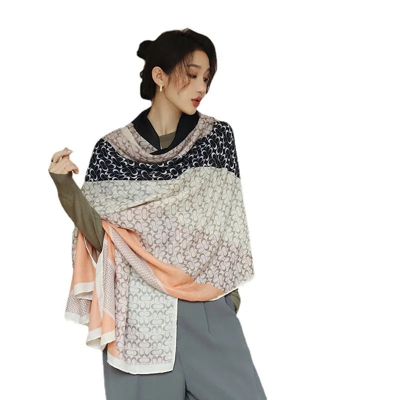 A woman wearing a printed polyester scarf, showing one of three style options, with dimensions of 180cm by 90cm.