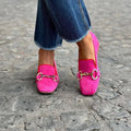 Green suede women's loafers with round toe, metal fastener, and flat rubber sole on a white background