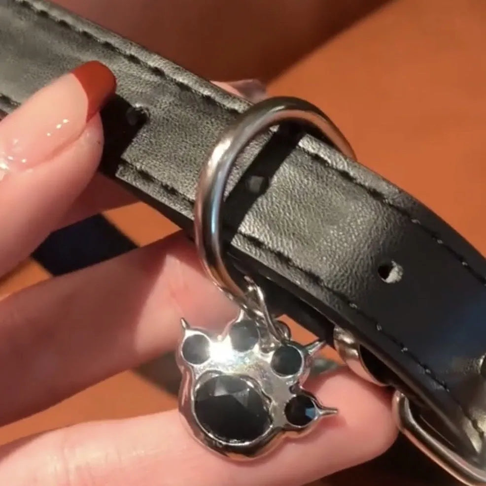 Black leather adjustable choker collar with cute bone or cat paw charm on a model.