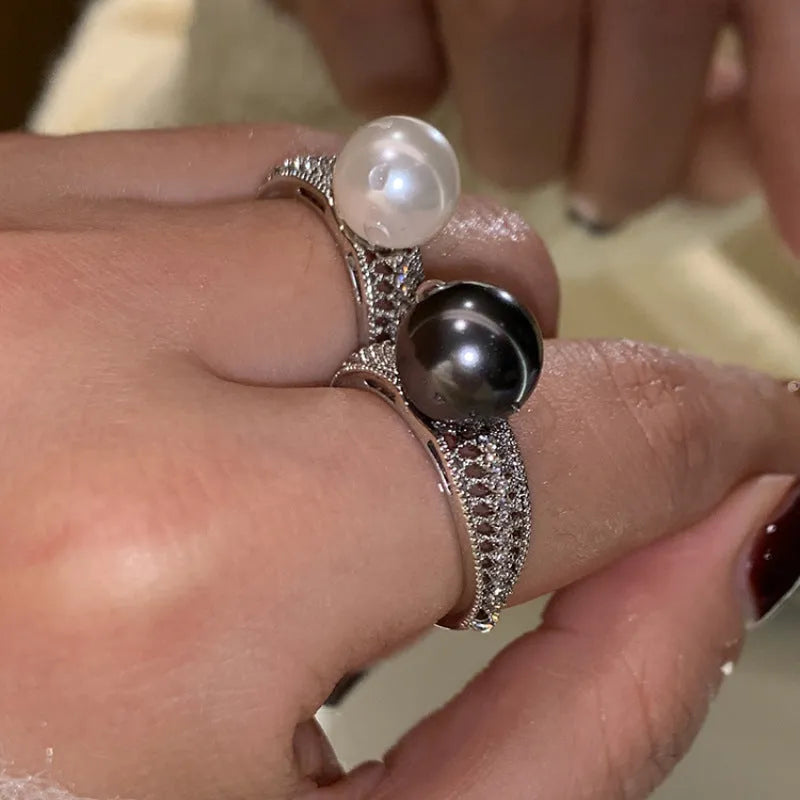 Geometric adjustable copper ring in black pearl finish on a finger.