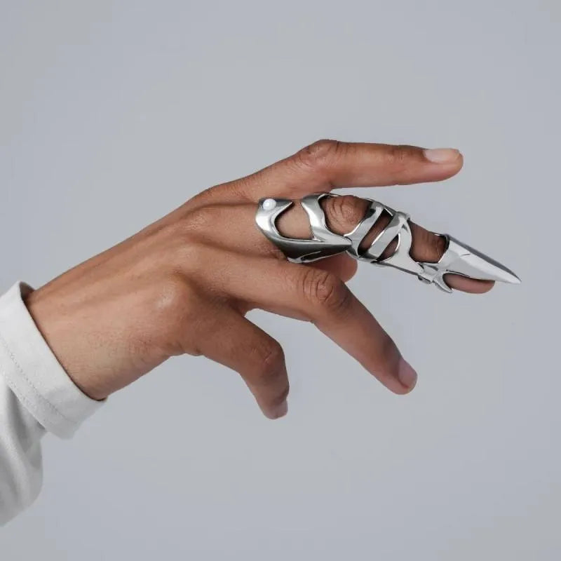 Silver coloured alloy punk armour finger stall ring on a hand.
