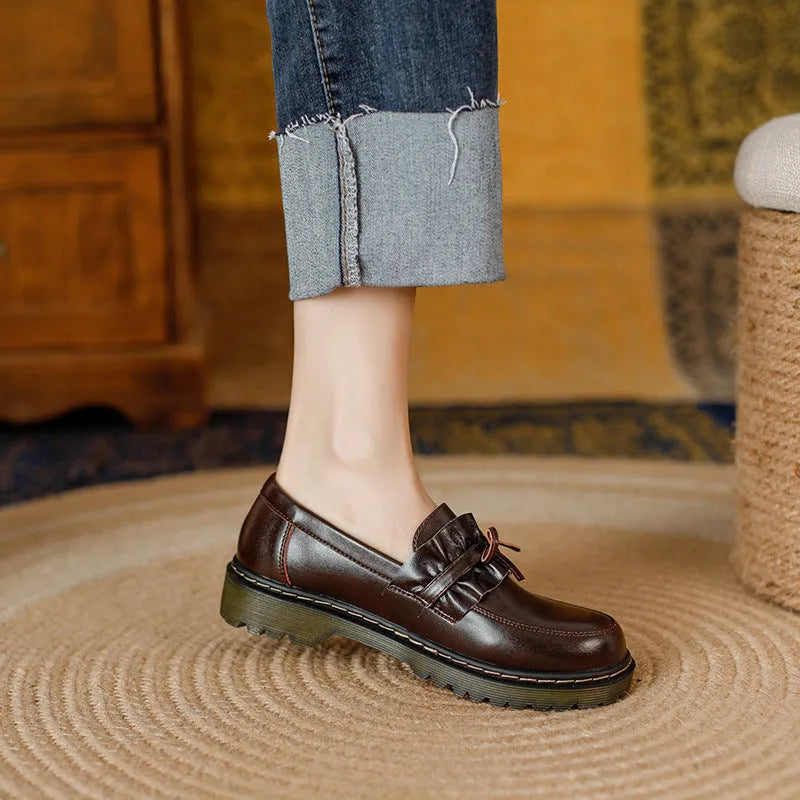 Women's black leather chunky heel shoes with a round toe and low-top design.