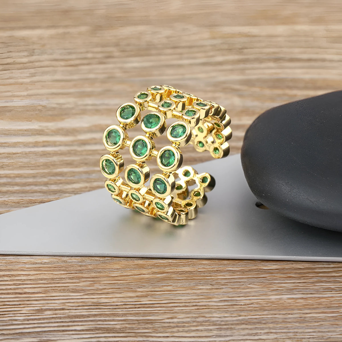 Copper ring with 18K gold plating showing three-layer design and green zircon stones