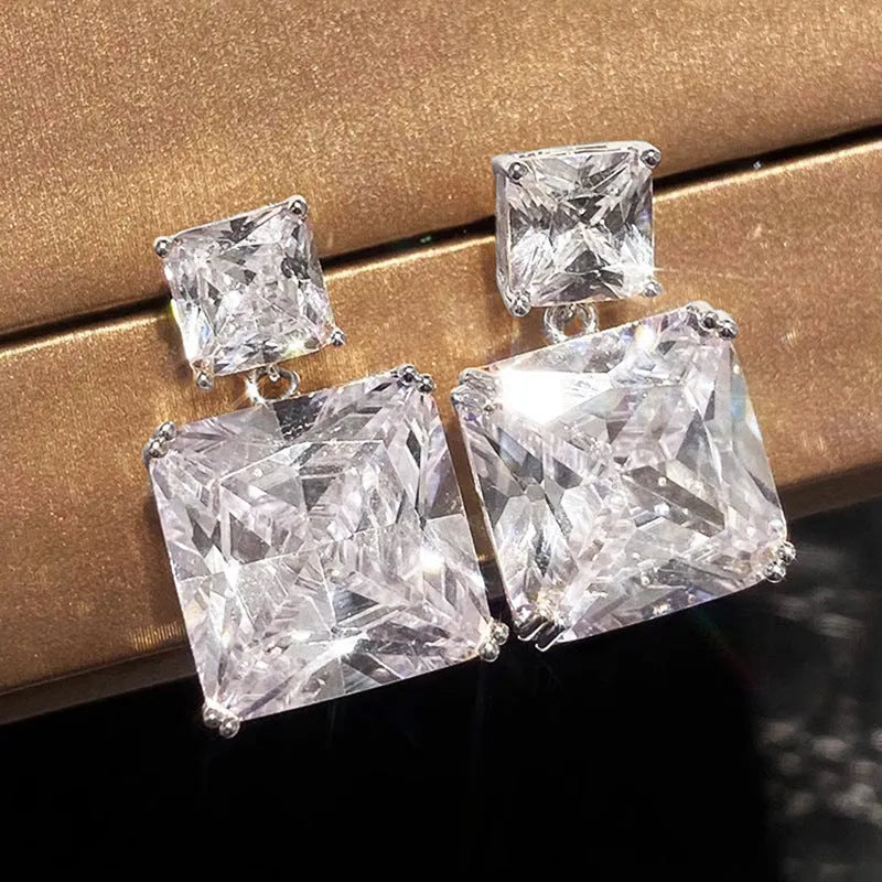 A pair of women's copper geometric square stud earrings in white gold or gold colour finish.