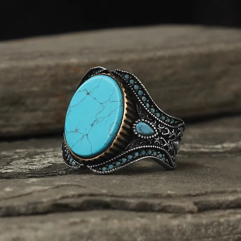 Men's antique silver alloy ring with a simple round turquoise stone, shown on a finger.