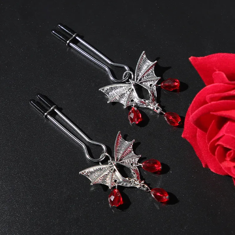 Silver coloured alloy bat-shaped nipple clamp with an adjustable screw mechanism.
