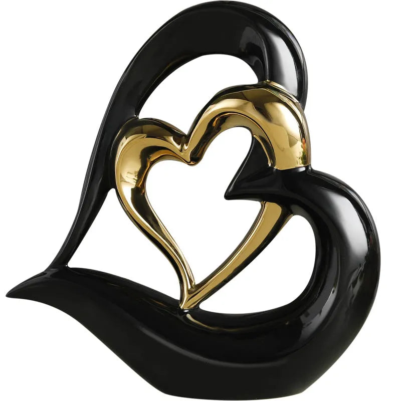 Modern geometric heart-shaped porcelain ornament in a metallic finish displayed on a cabinet.