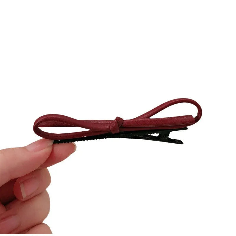 Wine red leather bow hair barrette showing manual craftsmanship and bow design details