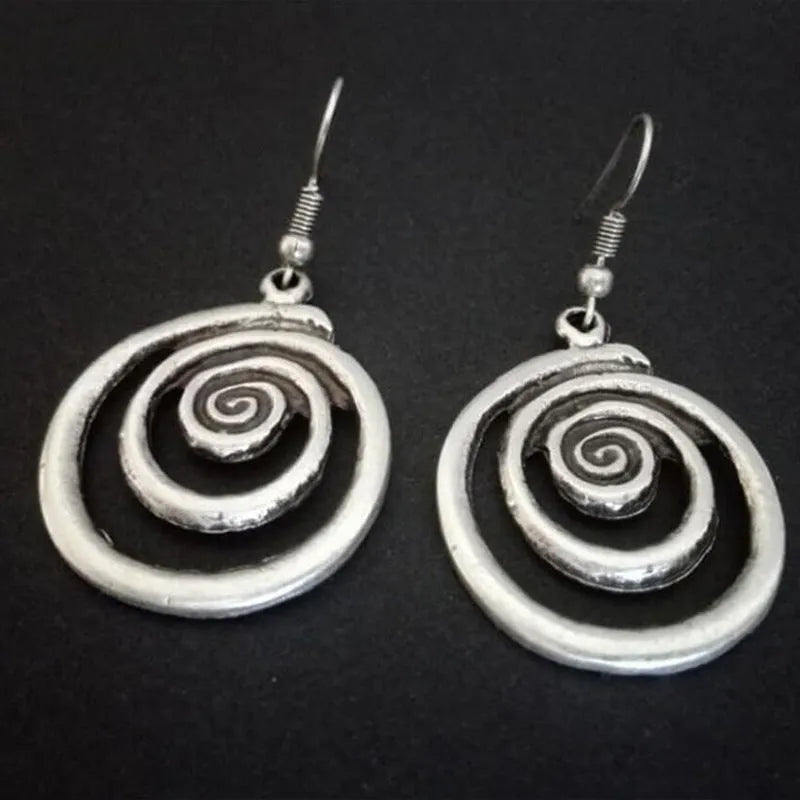 A pair of silver-coloured geometric spiral earrings with a distressed metal finish