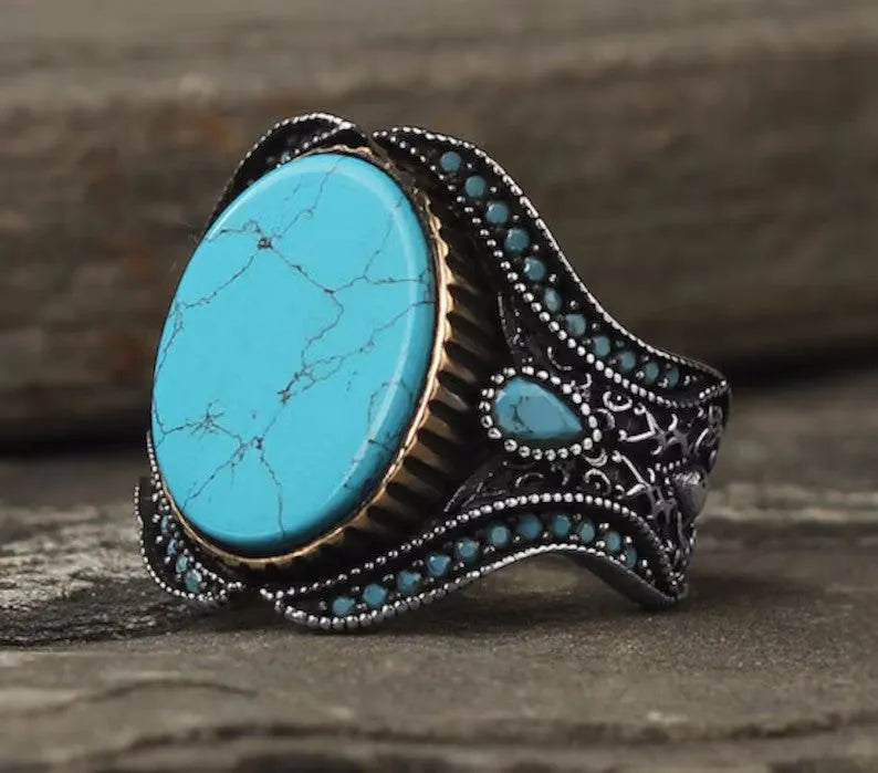 Men's antique silver alloy ring with a simple round turquoise stone, shown on a finger.