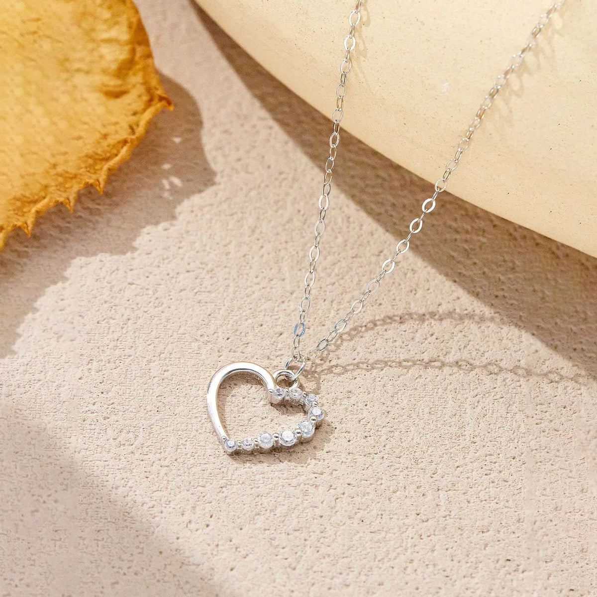 Sterling silver hollow heart necklace with circle elements, available in gold or platinum plating