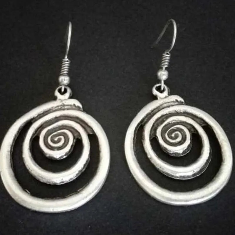 A pair of silver-coloured geometric spiral earrings with a distressed metal finish