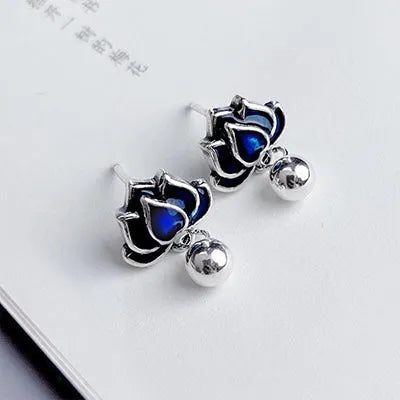 Blue lotus flower stud earrings with a seedpod tassel, showing front detail.