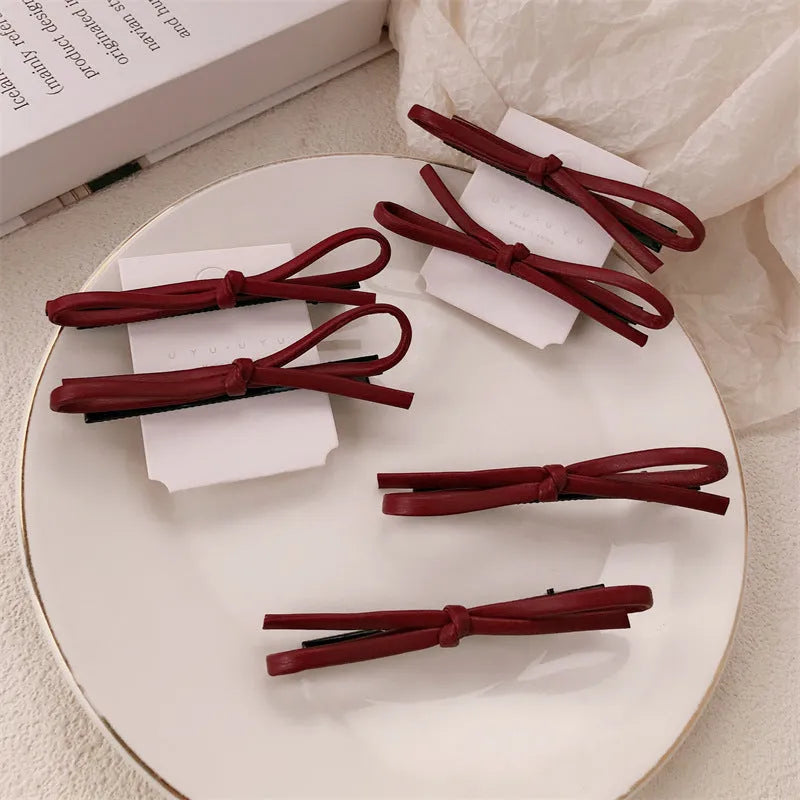 Wine red leather bow hair barrette showing manual craftsmanship and bow design details