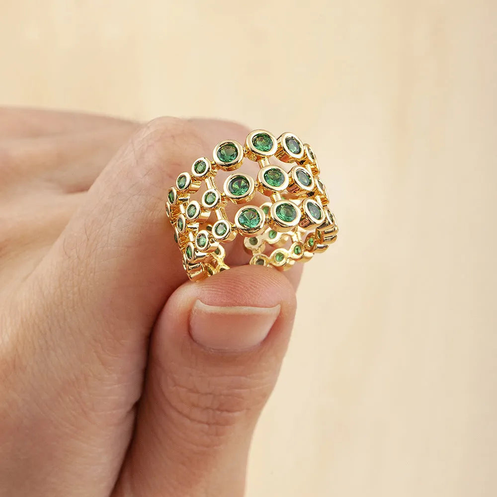 Copper ring with 18K gold plating showing three-layer design and green zircon stones