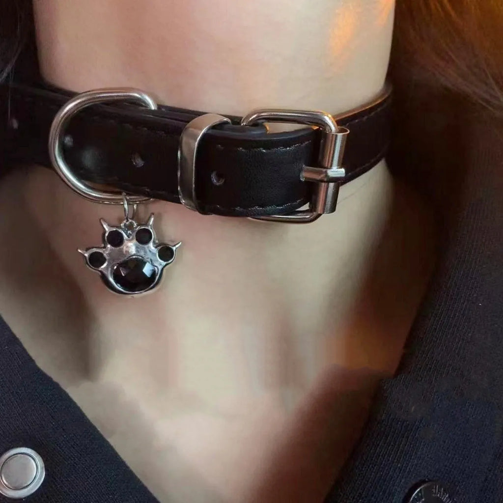 Black leather adjustable choker collar with cute bone or cat paw charm on a model.