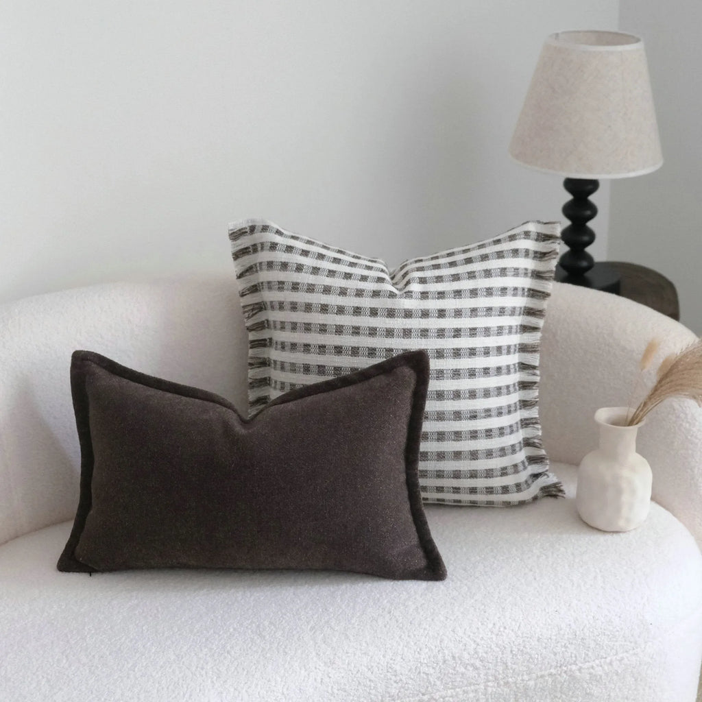 Coffee brown striped mid-century decorative cushion pillow on a grey sofa