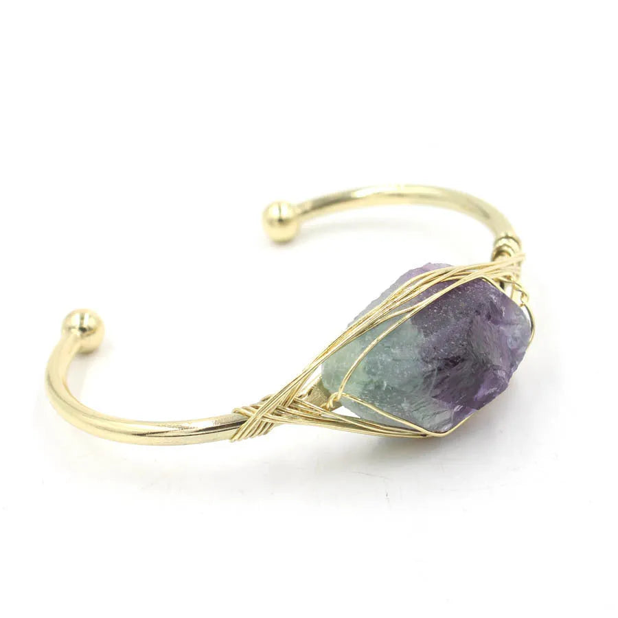 Natural raw gemstone bracelet in winding design on wrist, showing amorphous crystal stones and simple clasp.