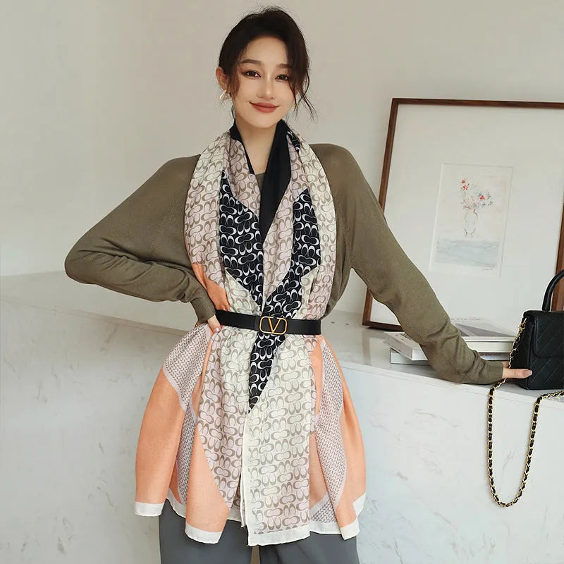 A woman wearing a printed polyester scarf, showing one of three style options, with dimensions of 180cm by 90cm.