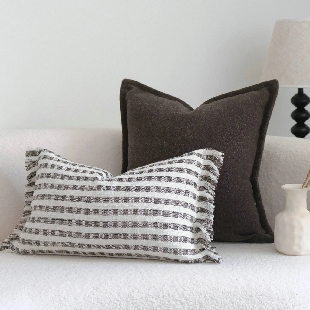 Coffee brown striped mid-century decorative cushion pillow on a grey sofa