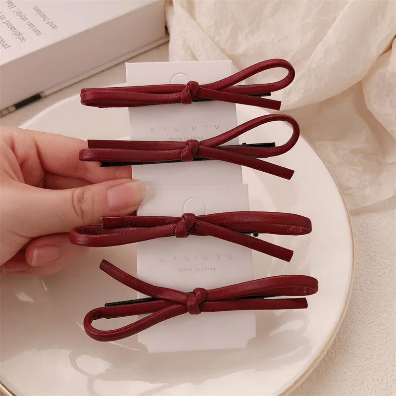 Wine red leather bow hair barrette showing manual craftsmanship and bow design details