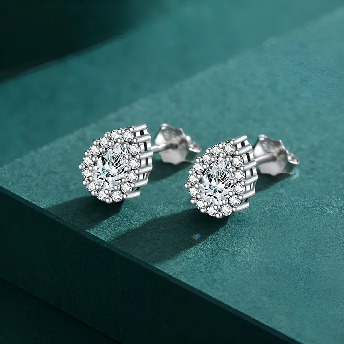 A pair of women's sterling silver water drop ear studs with a diamond-cut shiny finish.
