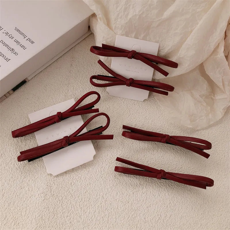 Wine red leather bow hair barrette showing manual craftsmanship and bow design details