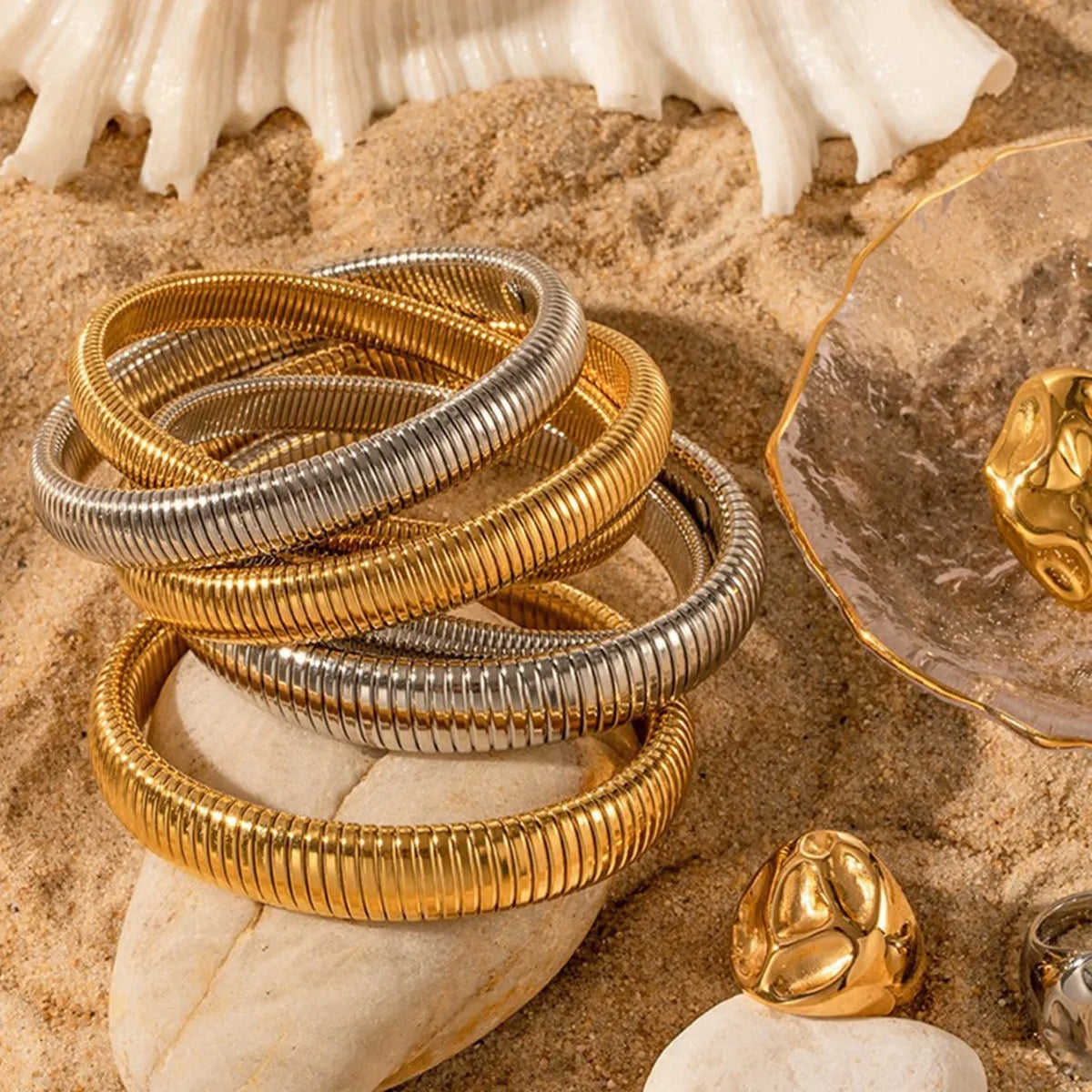 Gold titanium steel women's bracelet with vertical stripes and elastic ring design on a wrist.