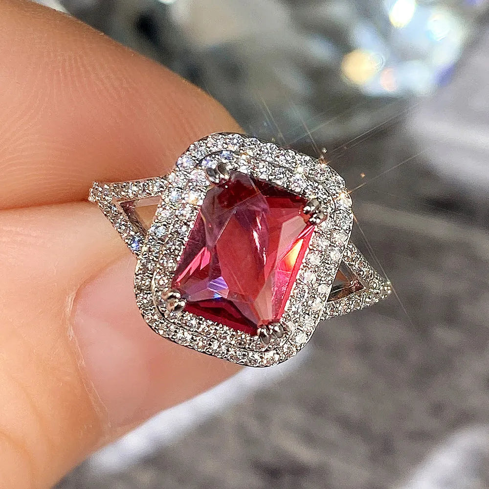 Red geometric square copper women's ring with rhinestone detailing on a white background.